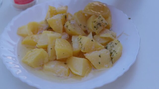 Woman picking up boiled potato with toothpick