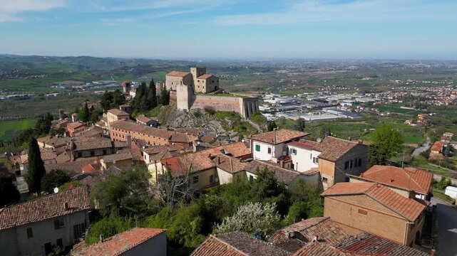 Breathtaking aerial drone view of the medieval Malatesta Fortress in Verucchio overlooking the vast Valmarecchia countryside and Adriatic coast under a clear sky in Emilia-Romagna, Italy