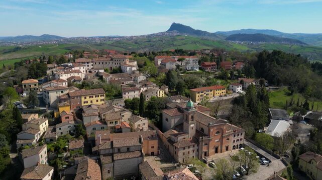 Breathtaking aerial drone view of the medieval Malatesta Fortress in Verucchio overlooking the vast Valmarecchia countryside and Adriatic coast under a clear sky in Emilia-Romagna, Italy