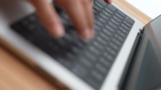 Close-up of a person typing on a laptop keyboard against a clean white background. This high-quality 4K footage captures hands writing, coding, or working remotely, making it perfect for technology