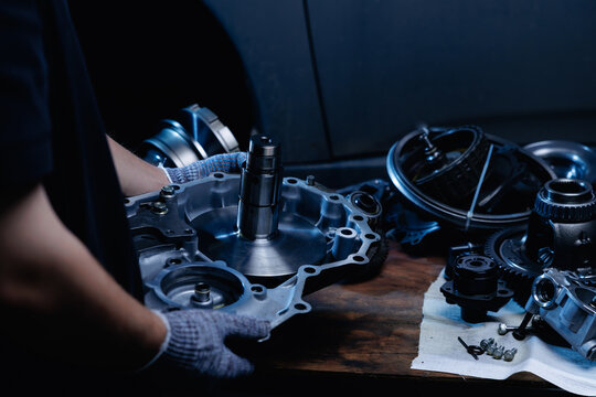 Mechanic hands assembling transmission housing on workbench