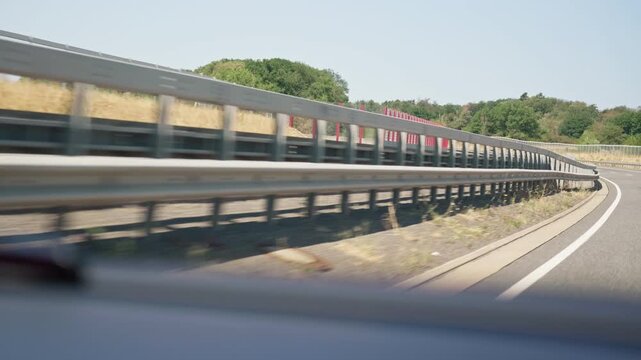Speeding highway guardrail view from car a bumpy road