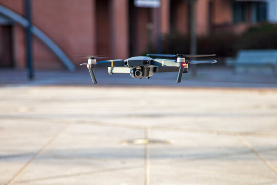 Drone quadcopter camera flying outdoors hovering in city, capturing aerial views and surveillance