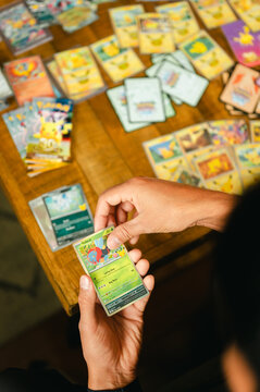 Chicago, IL/USA - September 19, 2026: A person sorts through Pok&eacute;mon trading cards from the 30th Celebration set while surrounded by a large collection of cards and opened booster packs