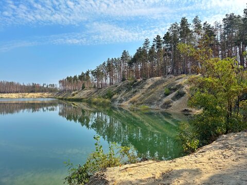Scenic Quarry Lake with Emerald Water and Pine Forest Reflection
