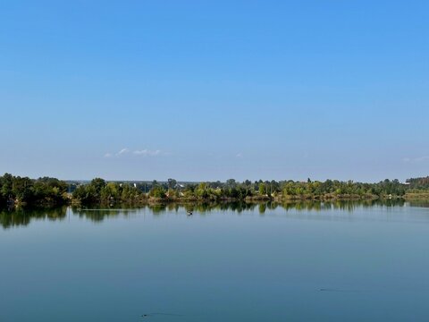 Tranquil Waterscape of Quarry Lake Under Clear Blue Sky