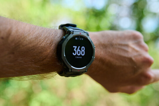 Smartwatch displaying burned calories tracking on a male wrist outdoors