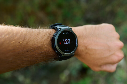 Smartwatch displaying fat burning zone heart rate 117 bpm on a male wrist