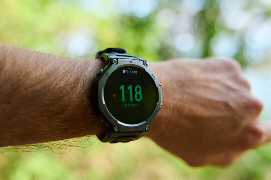 Smartwatch displaying fat burning zone heart rate 117 bpm on a male wrist