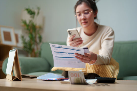 Woman checking a bank statement, credit card and smartphone while managing monthly payment at home, credit card debt, personal finance, household expenses, repayment, online banking financial pressure