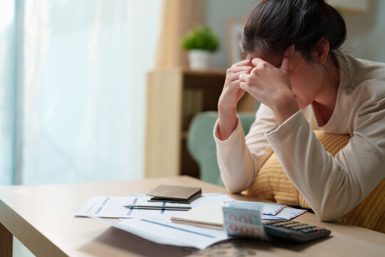 Stress woman sitting with bills, calculator, cash and financial documents at home, personal debt, unpaid expenses, financial hardship, household debt, repayment pressure cost of living problem