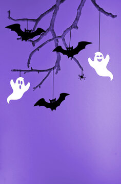 Halloween background with black bats sitting on tree.