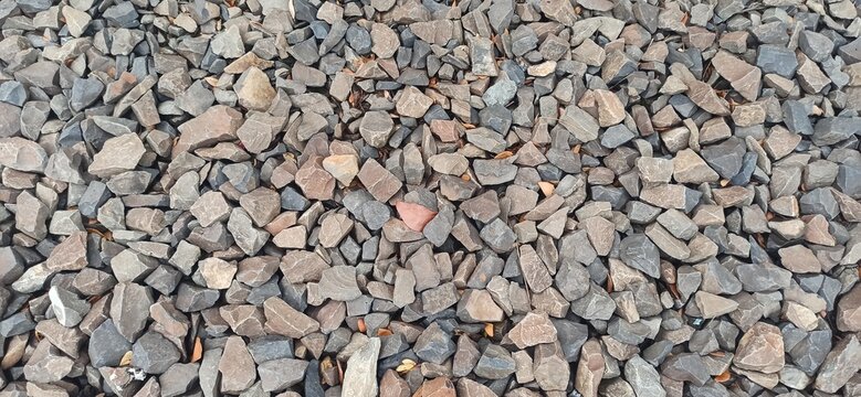 Natural texture of coarse gravel ballast used for railroad track foundation with high detail close up of rough crushed stones used to stabilize railway tracks