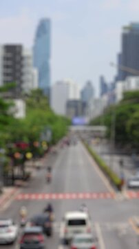 Bokeh view of road traffic near MBK Center, Bangkok, Thailand. Blurred background vertical timelapse footage.