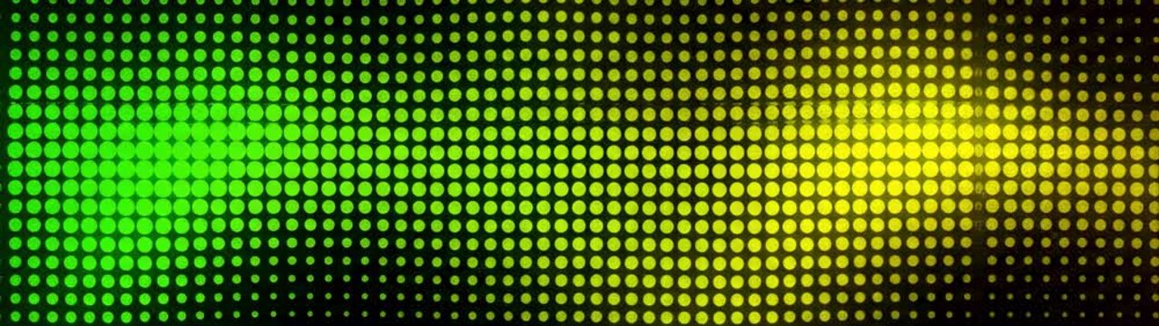 Halftone pattern creating a wave with green and yellow gradient on a dark surface Digital display screen dots.