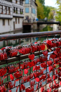Strasbourg, France, Alsace - Red love padlocks attached to a bridge railing over a canal in Strasbourg.