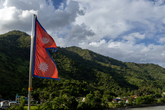 Nepal's Distinctive Double-Pennant National Flag Flying Against Green Himalayan Hills