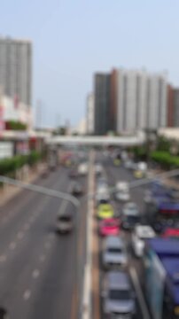 Bokeh view of road traffic in Thonburi district, Bangkok, Thailand. Blurred background vertical footage.