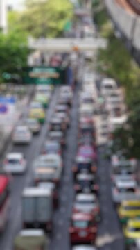 Bokeh view of road traffic at Phaya Thai road, Bangkok, Thailand. Blurred background vertical footage.