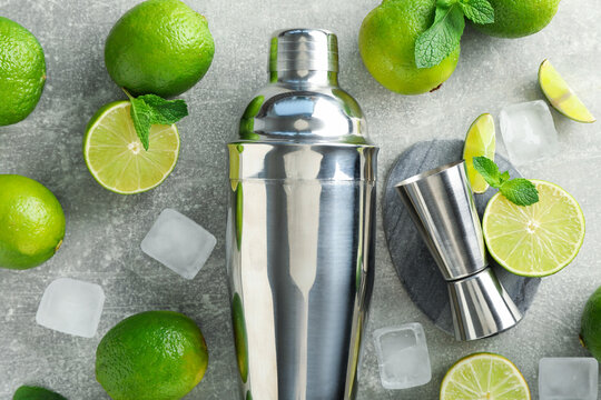 Ingredients for mojito, shaker and jigger on light grey table, flat lay