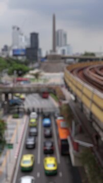 Bokeh view of road traffic near Victory Monument square, Bangkok, Thailand. Blurred background vertical footage.