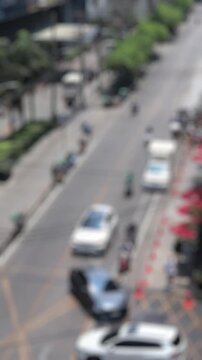 Bokeh view of road traffic near Asok BTS skytrain station, Bangkok, Thailand. Blurred background vertical footage.