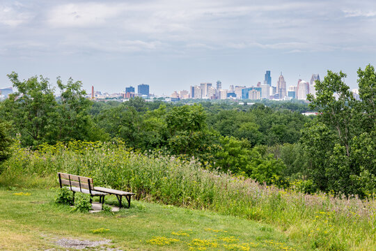 Peaceful park bench at Malden Park hill in Windsor Ontario lookout facing the distant Detroit skyline, a cross-border scene amidst intense tensions between Canada and the U.S. July 2026