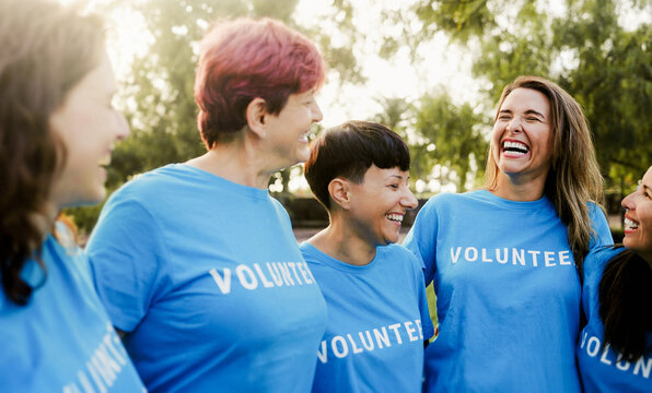 Multigenerational group of volunteer people celebrating together outdoors - Teamwork and women charity support concept