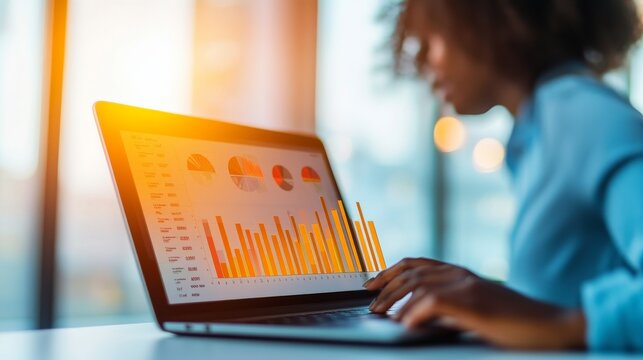 Amber Dawn Under a Careful Business Assessment: Analyst Reviewing Laptop Graphs With Real Time Dashboard Aler