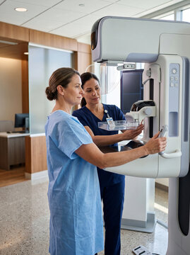 Female Patient Undergoing Mammography Screening Test Assisted by Radiologist Technician in Modern Hospital