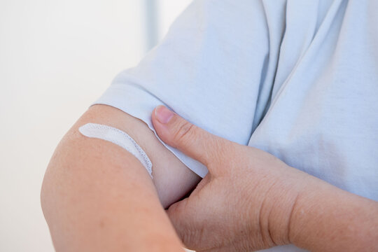 arm with patch on skin, indicating medical treatment, medical care, adhesive bandage, band-aid after blood donation, plaster after giving blood for medical tests and laboratory analysis