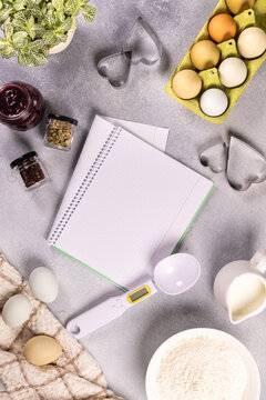 Baking ingredients with blank recipe notebook and heart cutters