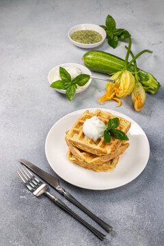 Zucchini waffles with cream and fresh basil for breakfast