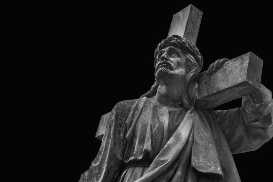 Dramatic statue of Jesus Christ carrying the cross on the way to Calvary, symbolizing sacrifice, suffering, faith, redemption and salvation.