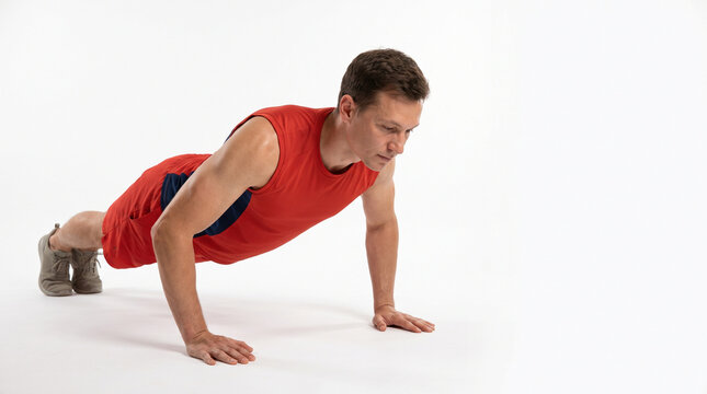 Young man doing push-ups on a white background in fitness attire  