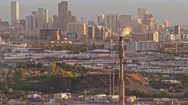 Chimney with flames oil refinery Denver skyline in the background drone video industrial view Colorado 4K