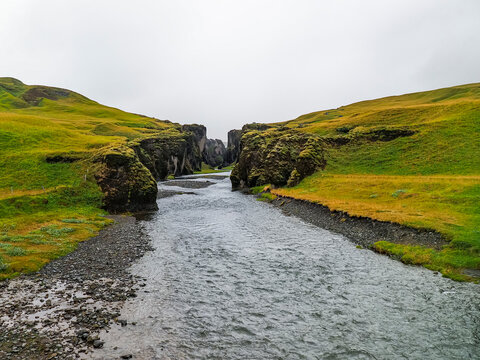 Rainy and cloudy day. Blurry view. Panoramic sight to winding Fjadra river and beautiful "Feather river canyon" or Fjadrargljufur canyon - deep moss-covered cliffs. Kirkjubaejarklaustur. South Iceland