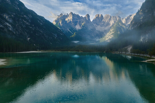 Scenic Dolomites Lake with Rugged Mountain Peaks and Forest Reflections