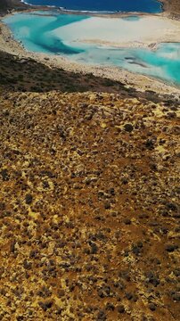 Vertical video aerial reveal of Balos Lagoon from rocky terrain