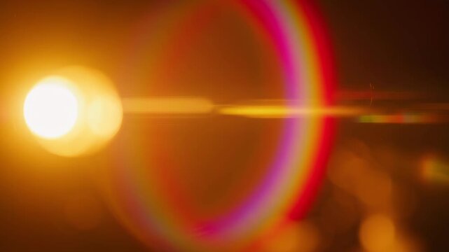 Golden lens flare evolving with warm light during a slow camera push in a dark cinematic setting