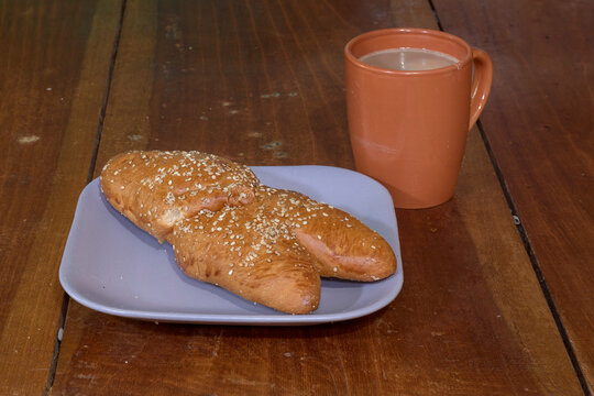 Traditional human-shaped bread with hot chocolate for the Day of the Dead celebration.