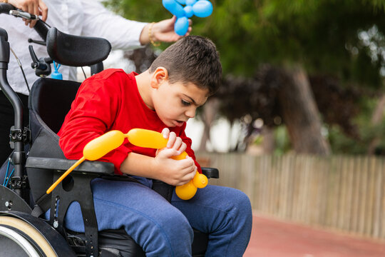 Child with cerebral palsy playing with balloon