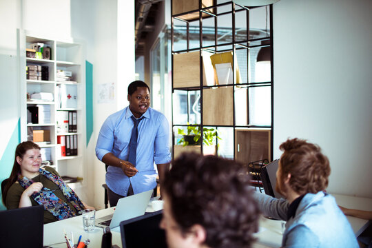 Coworkers collaborating during team meeting in modern office