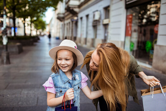 Mother and daughter shopping on city street