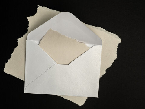 Open White Envelope With Torn Paper On Black Background, Stationery And Letter Concept