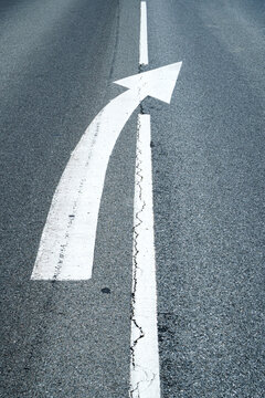 White arrow painted on asphalt guides traffic direction