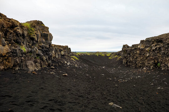 Volcanic landscape with rugged lava fields, black sand and poor local vegetation, and the dramatic scenery of the Reykjanes Peninsula, Iceland, next to Bridge Between Continents (Br&uacute; Milli Heims&aacute;lfa).
