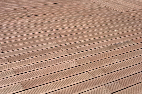 Dark brown composite wooden deck flooring planks.
