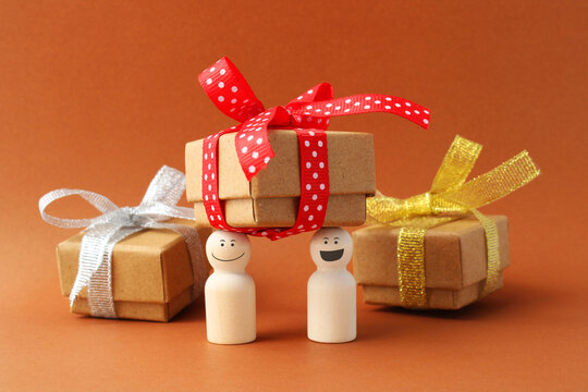 Partners hold one of three gift boxes with a bow