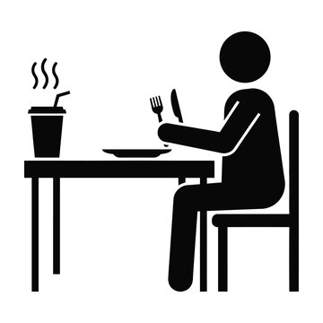 Person sitting at table eating with fork and knife